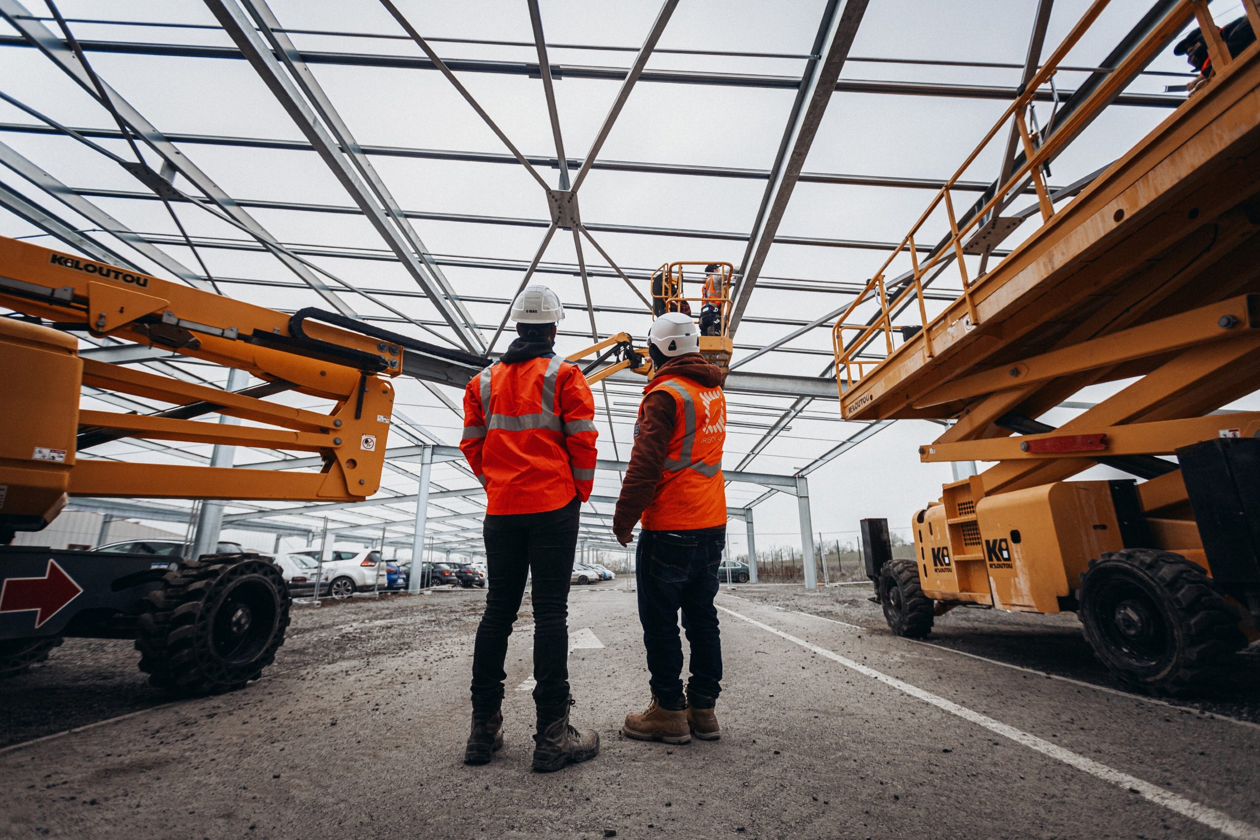 Ouvriers sur chantier avec structure métallique et engins