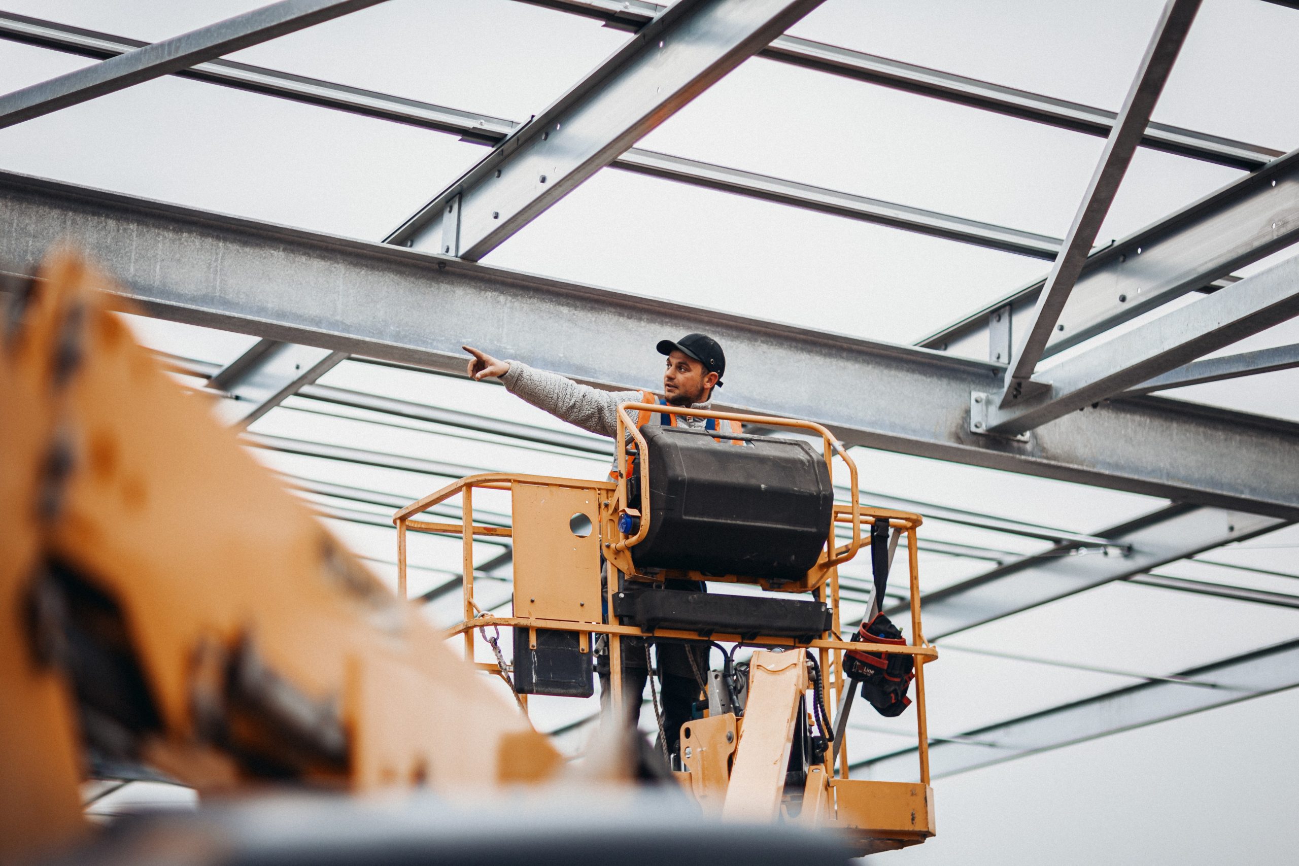Homme sur une nacelle de construction sur le chantier d'un bâtiment