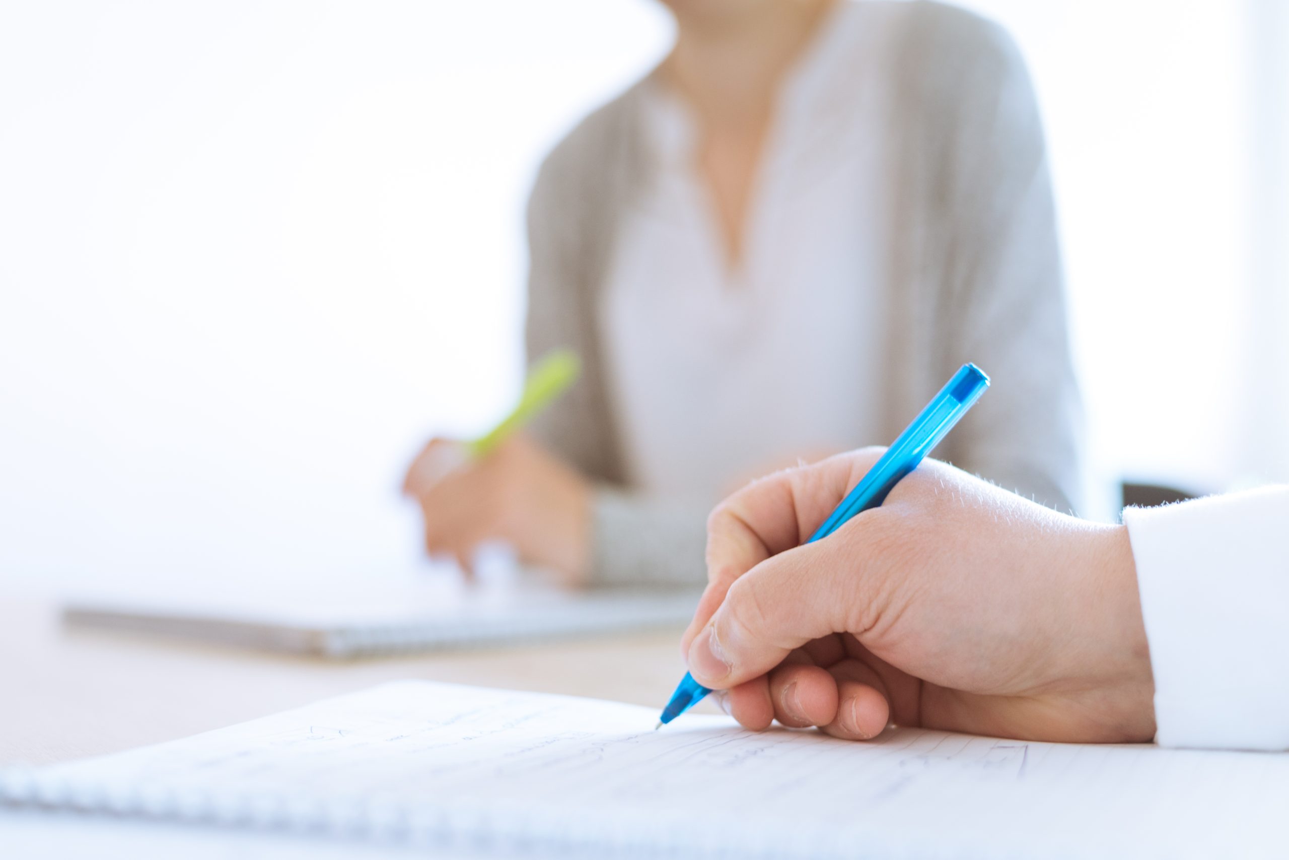 Main en train d'écrire sur un cahier