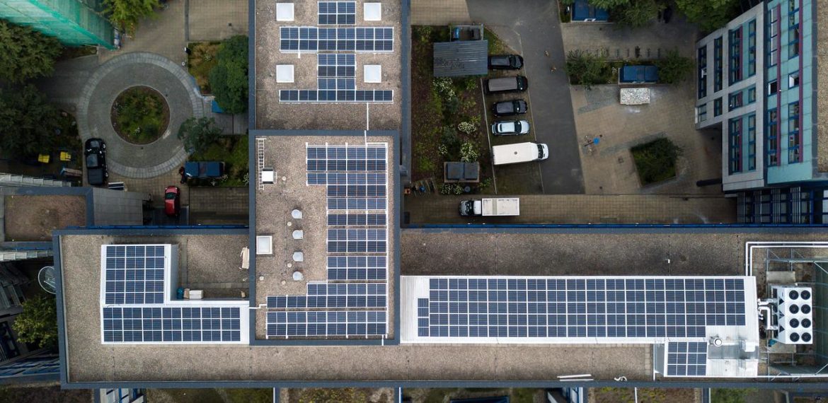 Vue aérienne de panneaux solaires installés sur les toits d’un bâtiment en milieu urbain